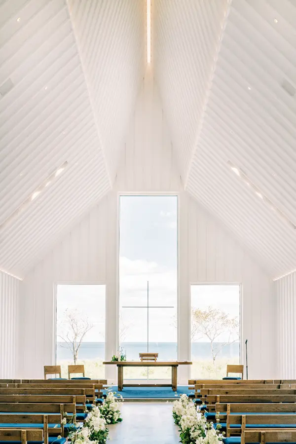 White chapel with ocean view and floral aisle