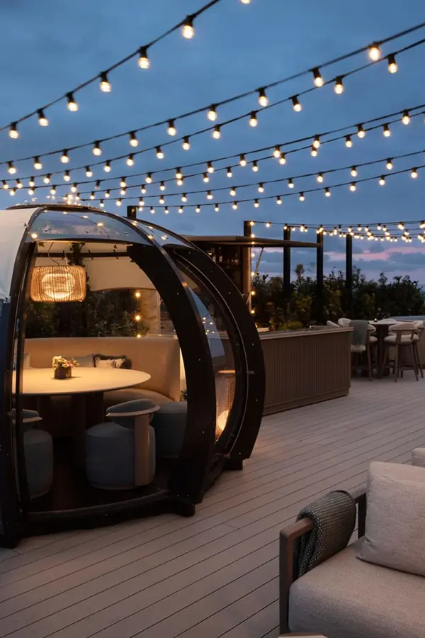 Rooftop terrace with pod seating and string lights