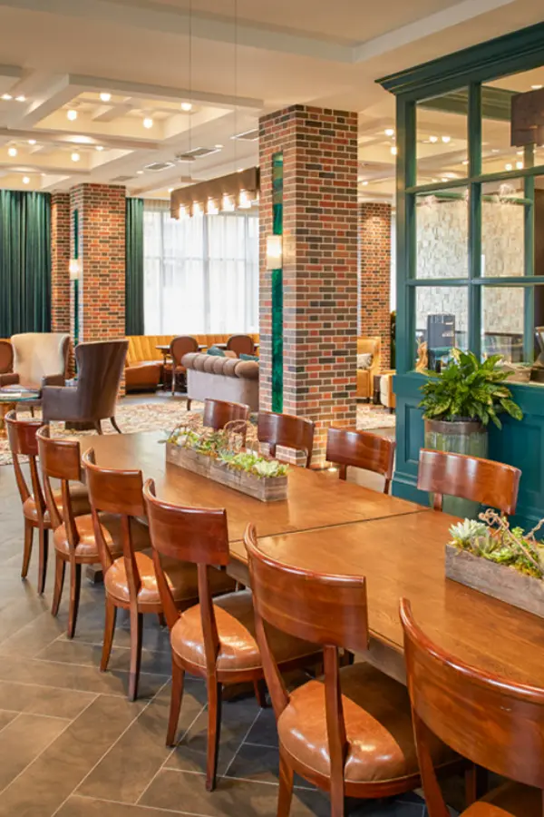 Communal dining space with brick pillars and teal accents
