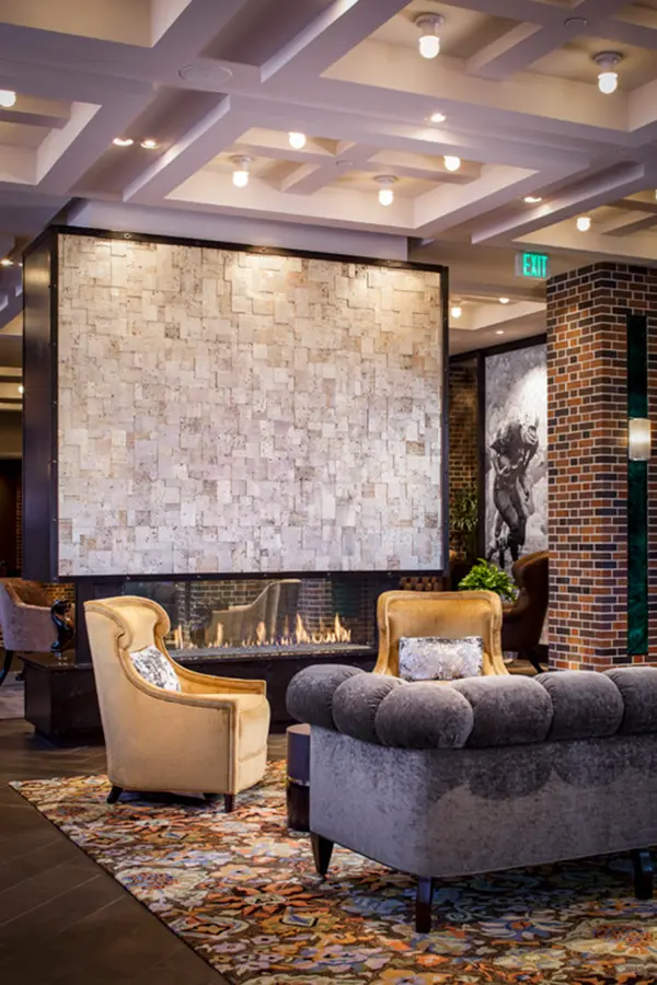 Hotel lobby with stone fireplace wall and brick columns