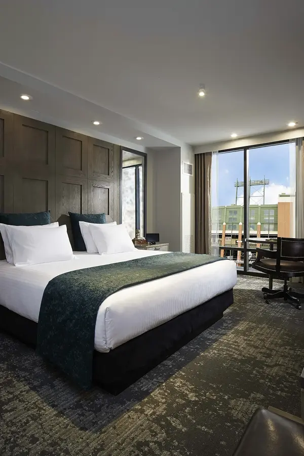Boutique hotel room with paneled headboard and teal accents
